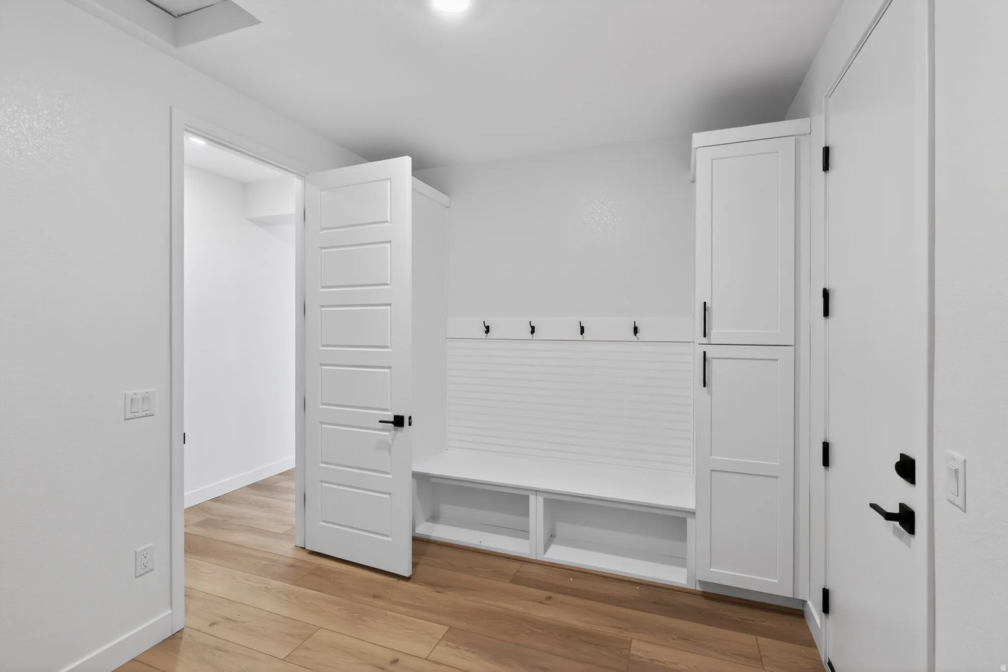 Mudroom with light wood-style flooring and baseboards