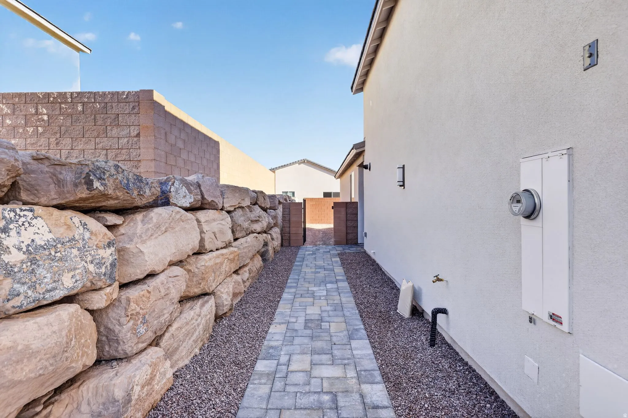 View of side of property featuring a gate and stucco siding