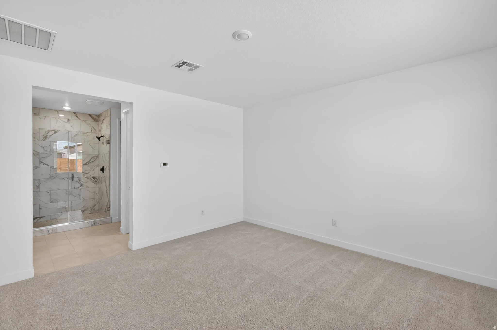 Unfurnished room featuring baseboards and light colored carpet