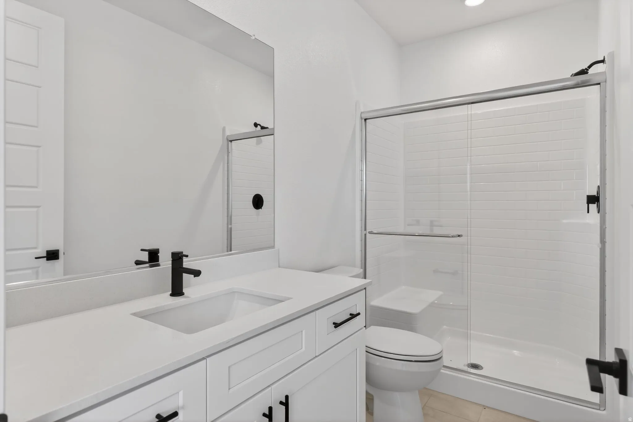 Full bath with vanity, a stall shower, light tile patterned floors, and recessed lighting