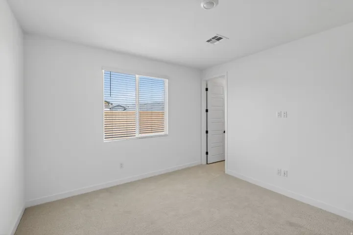 Empty room featuring light carpet and baseboards