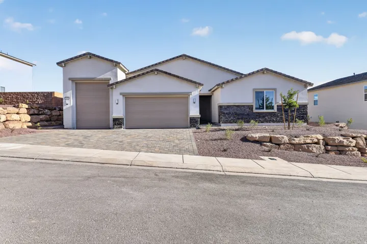 View of front of home featuring stone siding, a garage, stucco siding, decorative driveway, and a tile roof