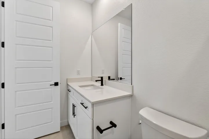 Bathroom featuring a textured wall and vanity