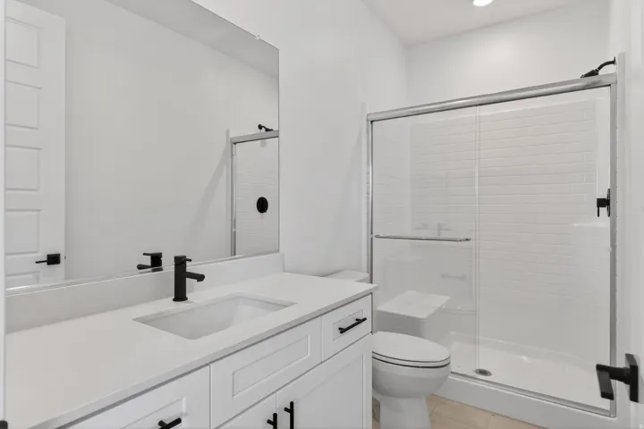 Full bath with vanity, a stall shower, light tile patterned floors, and recessed lighting
