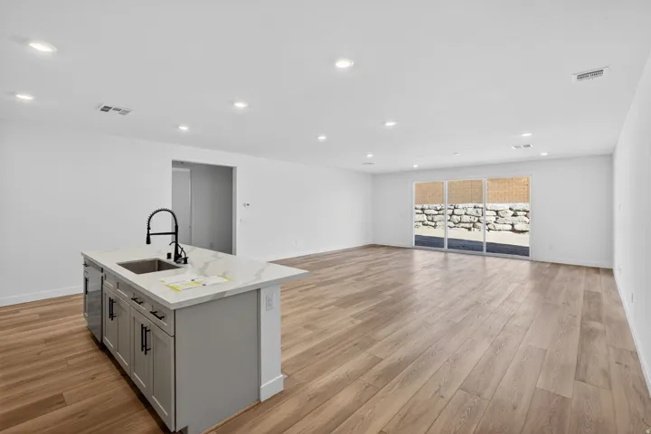 Kitchen featuring a kitchen island with sink, gray cabinets, light wood-type flooring, recessed lighting, and open floor plan