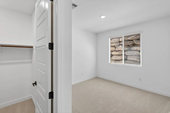 Spare room featuring light colored carpet and baseboards