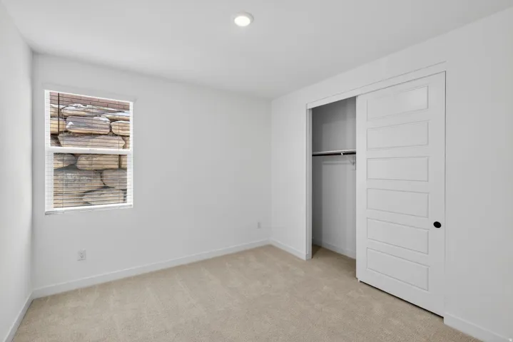 Unfurnished bedroom featuring light colored carpet and a closet
