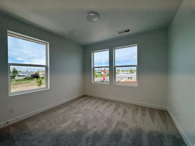 Spare room featuring light carpet and a textured ceiling