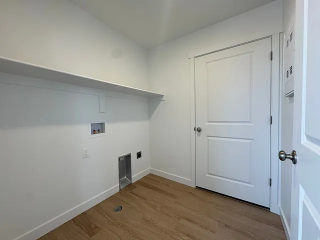 Laundry area featuring wood finished floors, washer hookup, and electric dryer hookup