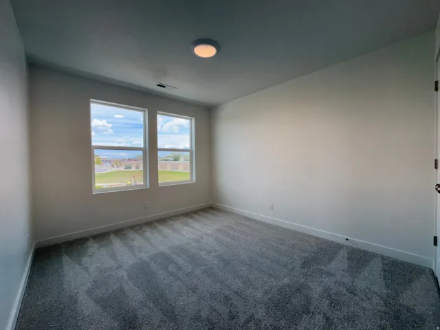 Empty room featuring carpet and baseboards