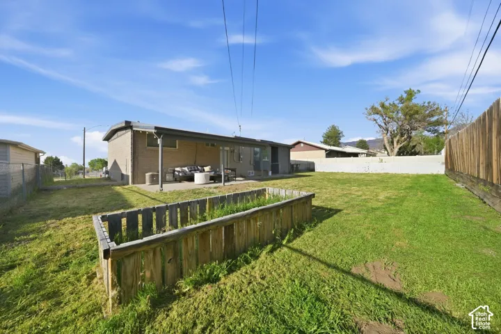Rear view of house featuring a fenced backyard, an outdoor lounge area, a patio area, and brick siding