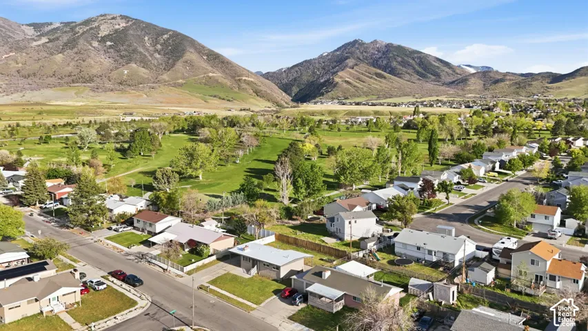 Aerial view of residential area featuring a mountainous background and a local golf course