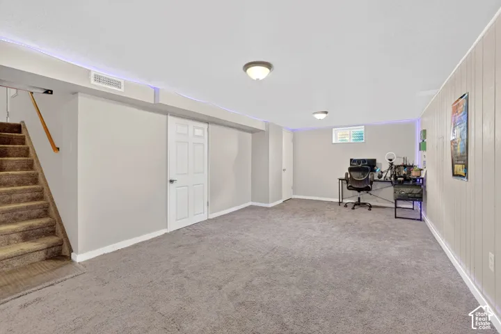 Office area with light carpet and wooden walls