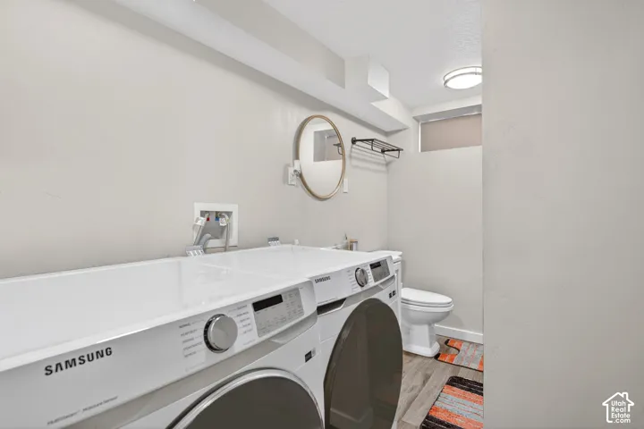 Laundry area featuring light wood finished floors and washer and clothes dryer
