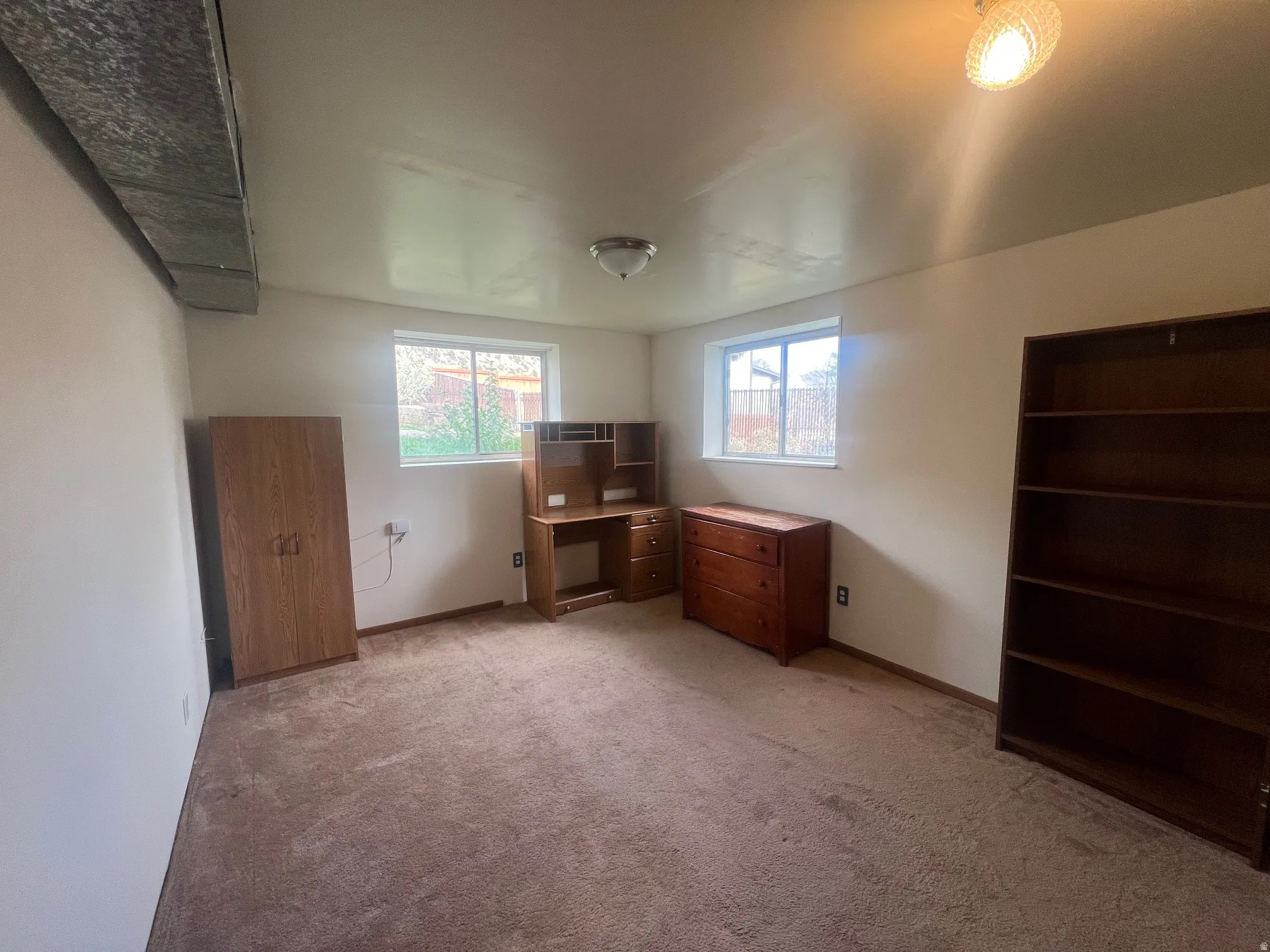 Unfurnished bedroom with light colored carpet and baseboards