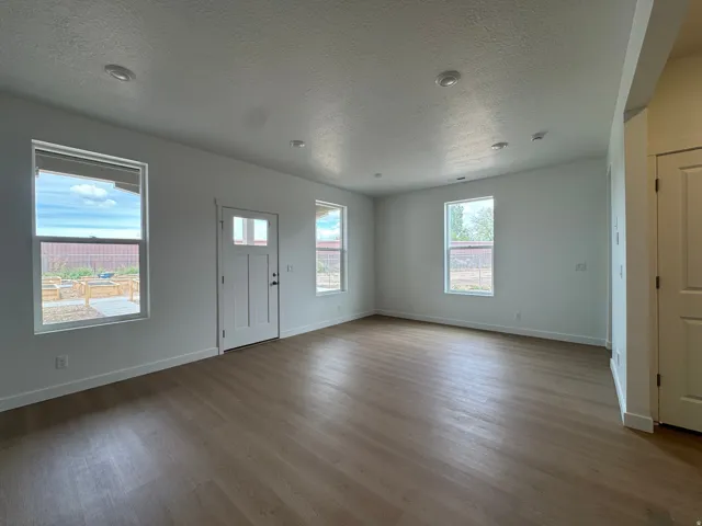Entrance foyer with a textured ceiling and dark wood-style floors