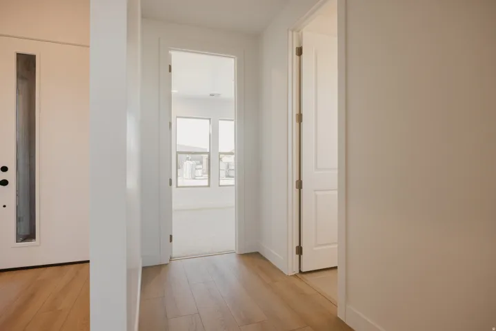 Hallway featuring light wood finished floors and baseboards