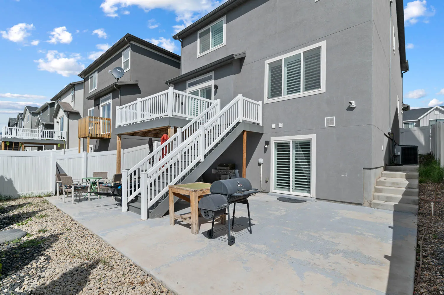 Back of property with a fenced backyard, a patio area, stucco siding, and a deck