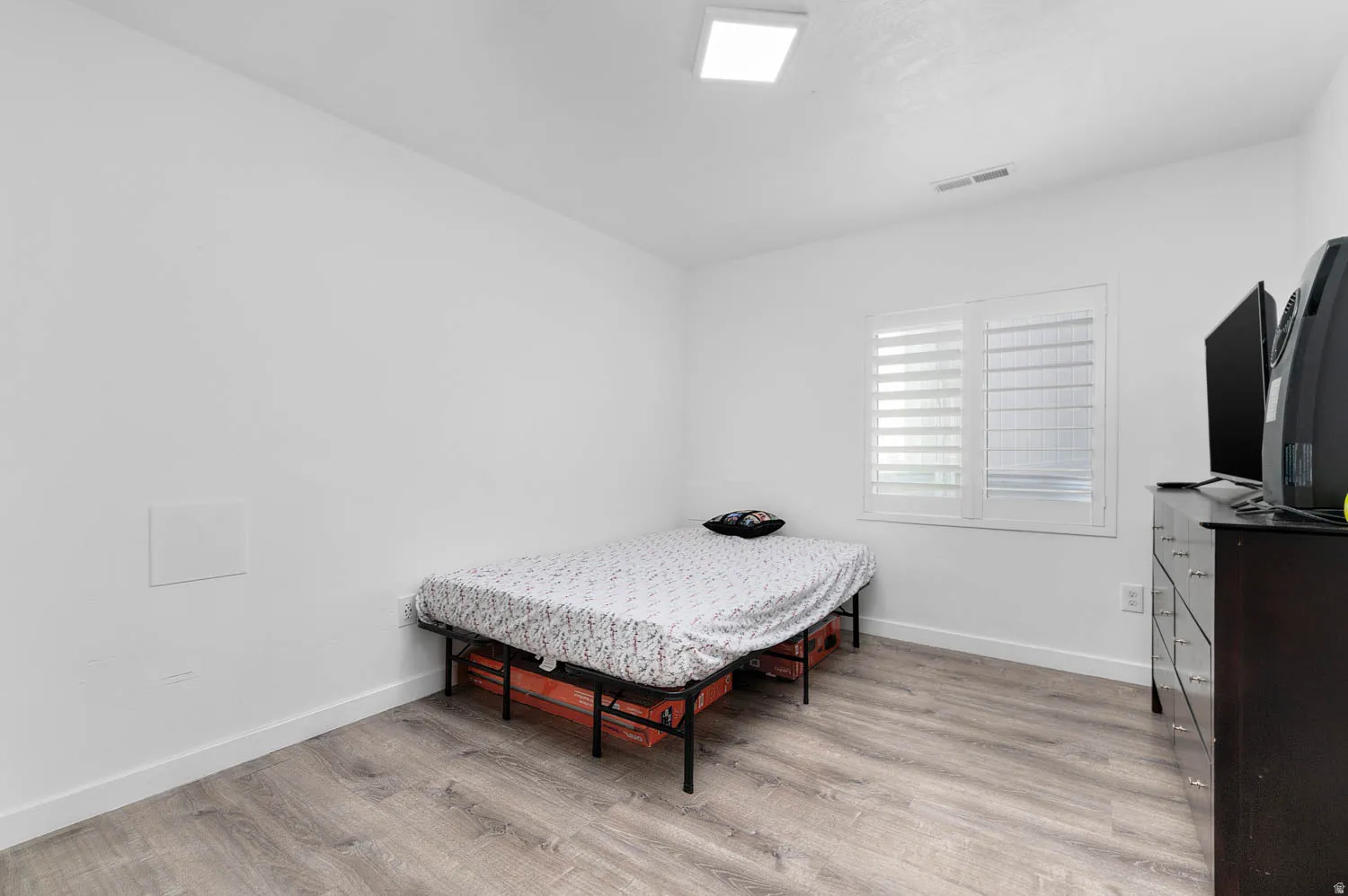 Bedroom with light wood-type flooring and baseboards