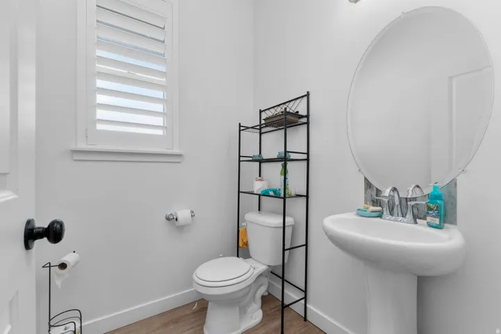 Half bath featuring toilet and light wood-type flooring