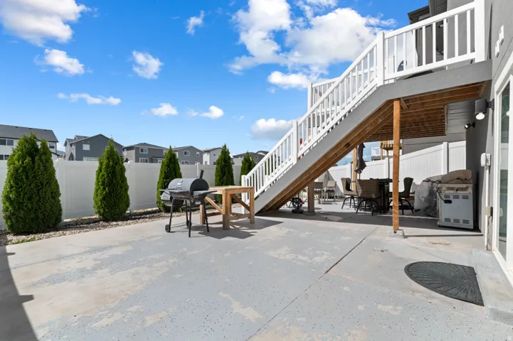 Fenced backyard with a residential view, outdoor dining area, area for grilling, a patio area, and a wooden deck