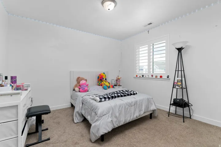 Bedroom featuring light colored carpet