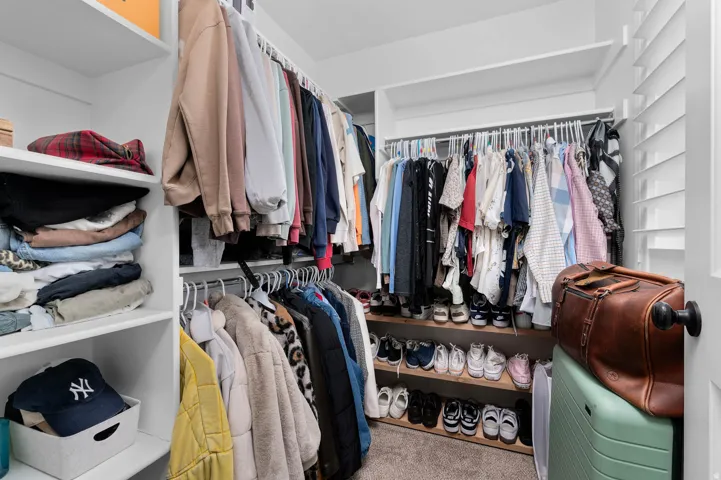 Walk in closet with light colored carpet