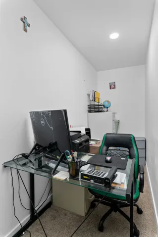 Home office with light carpet and baseboards