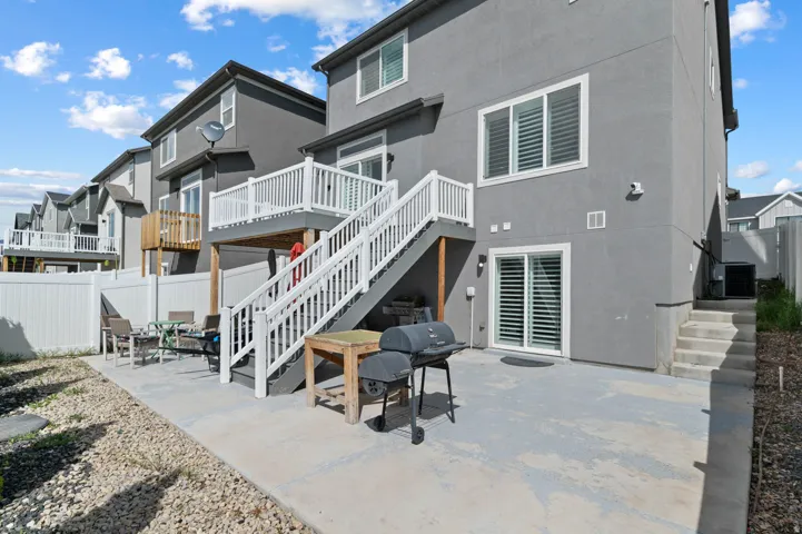 Back of property with a fenced backyard, a patio area, stucco siding, and a deck