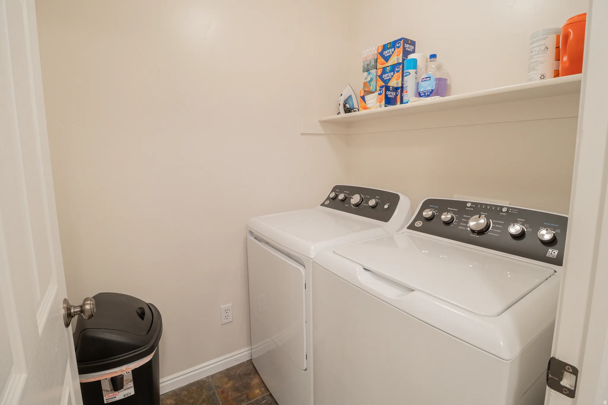 Laundry room with separate washer and dryer and stone finish flooring