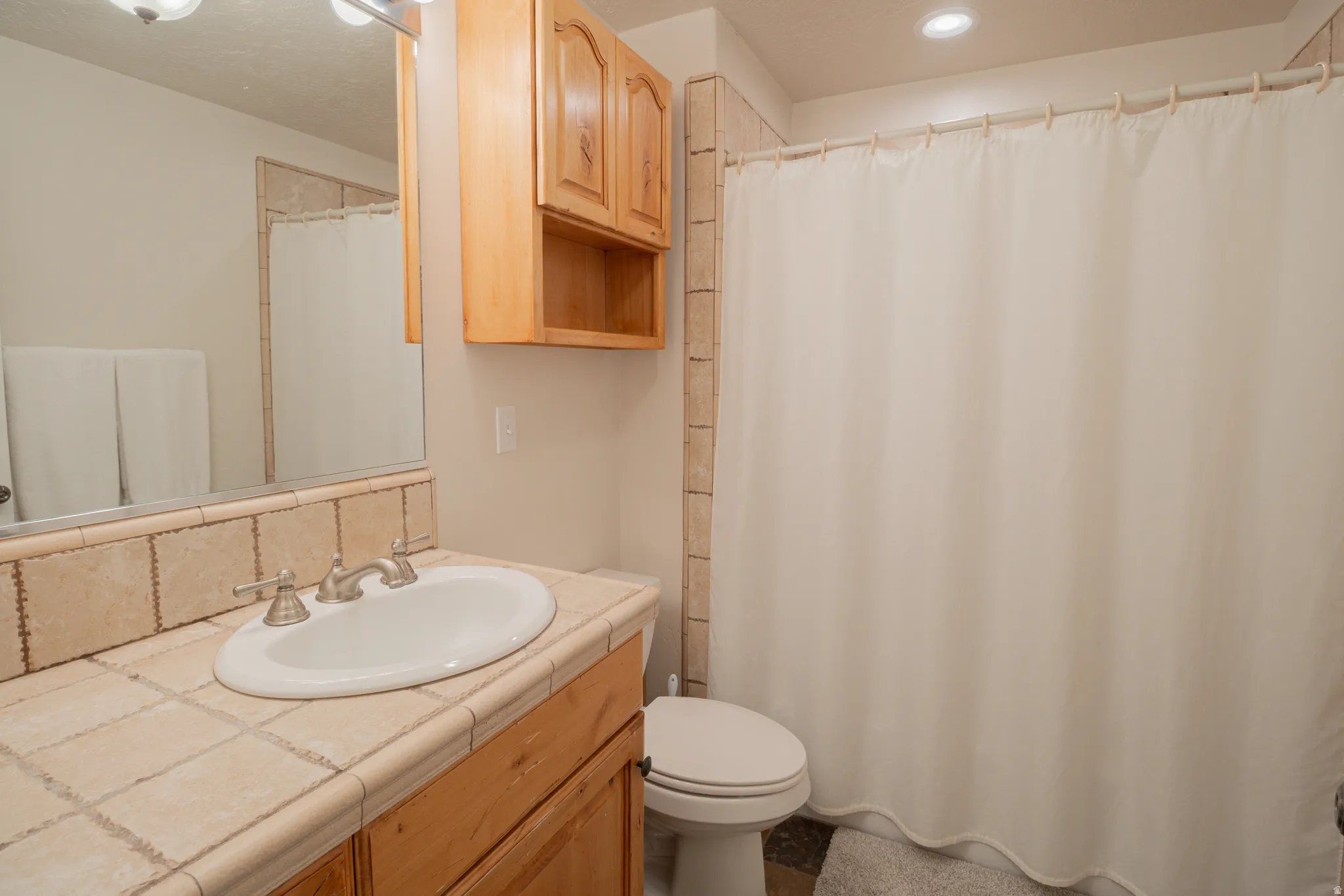 Bathroom with a shower with curtain and vanity