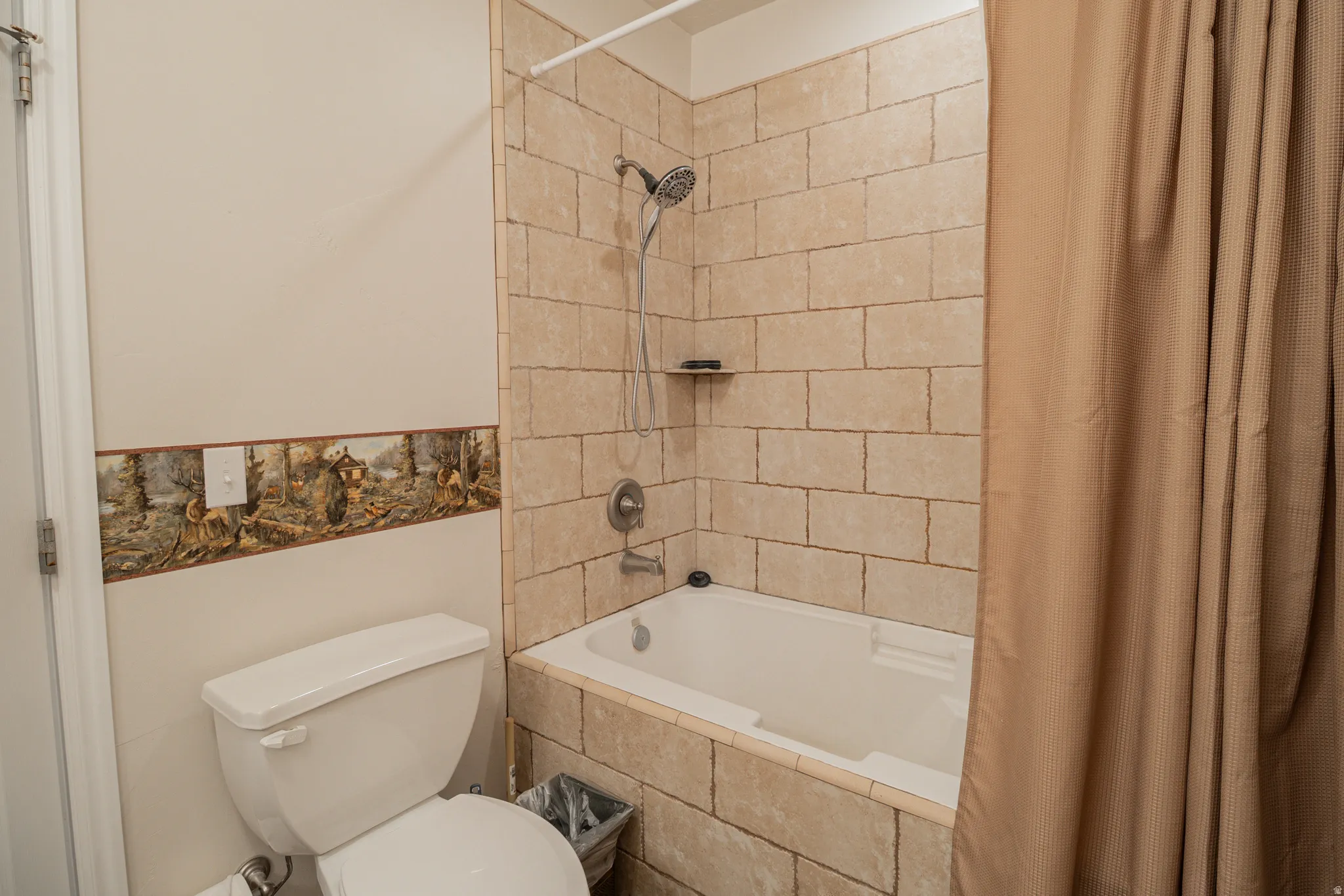Bathroom featuring toilet and tiled shower / bath
