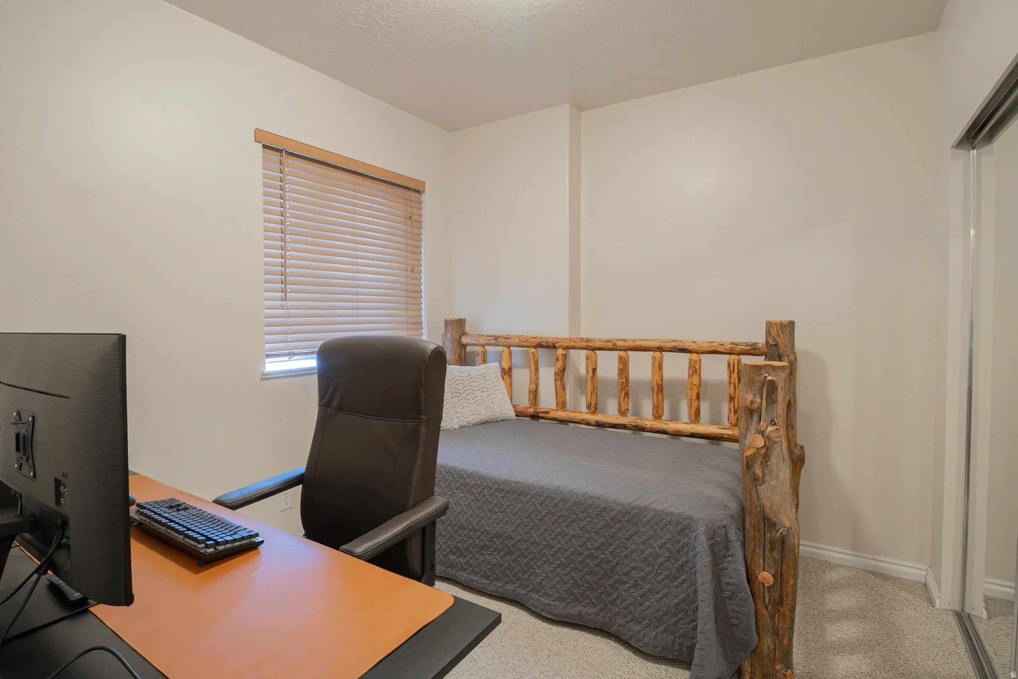 Bedroom with a desk and light colored carpet