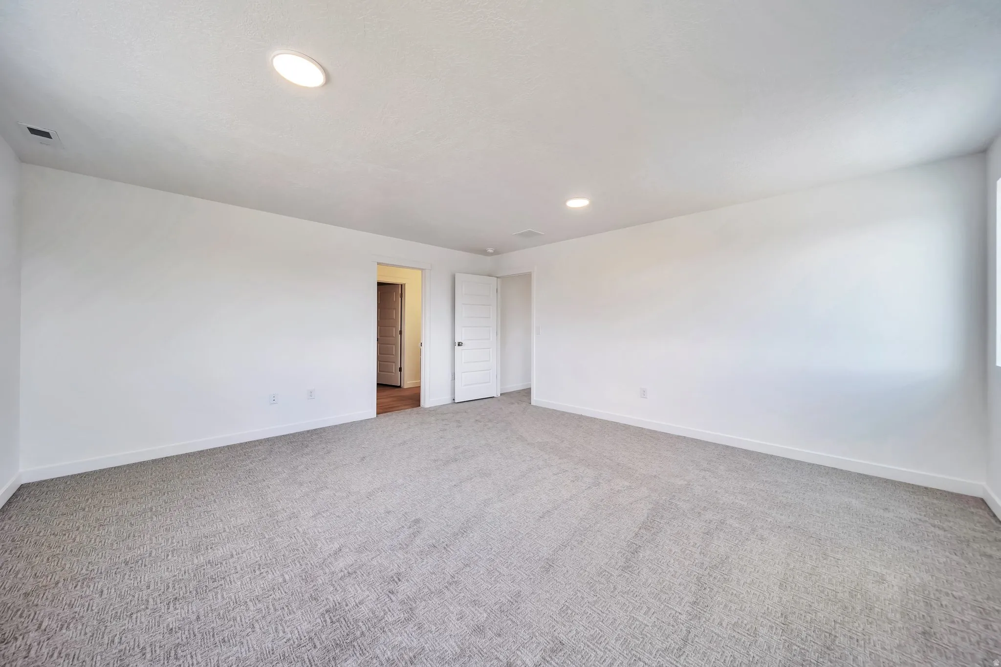 Empty room featuring light carpet and recessed lighting