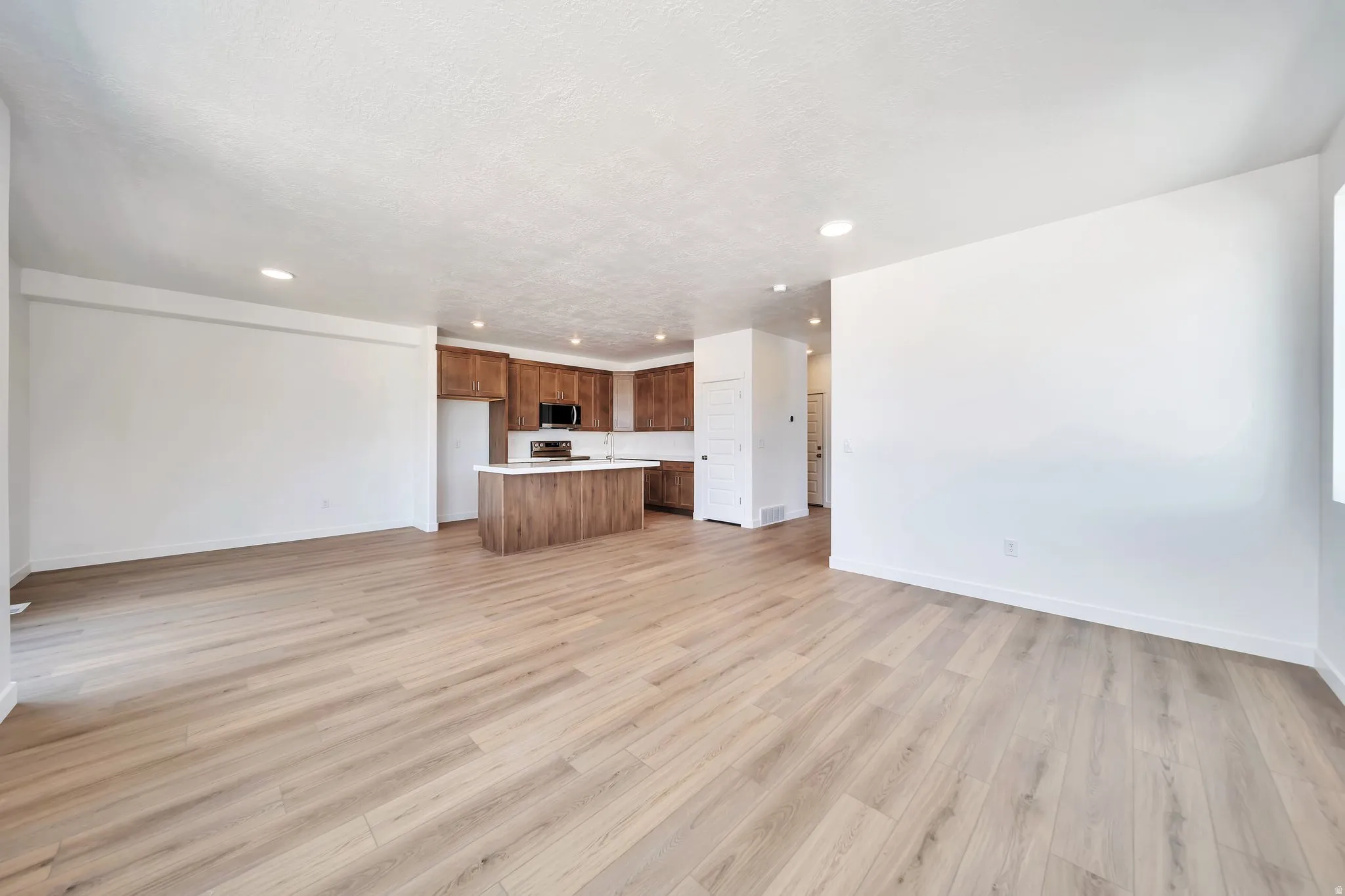 Unfurnished living room featuring light wood-style flooring and recessed lighting