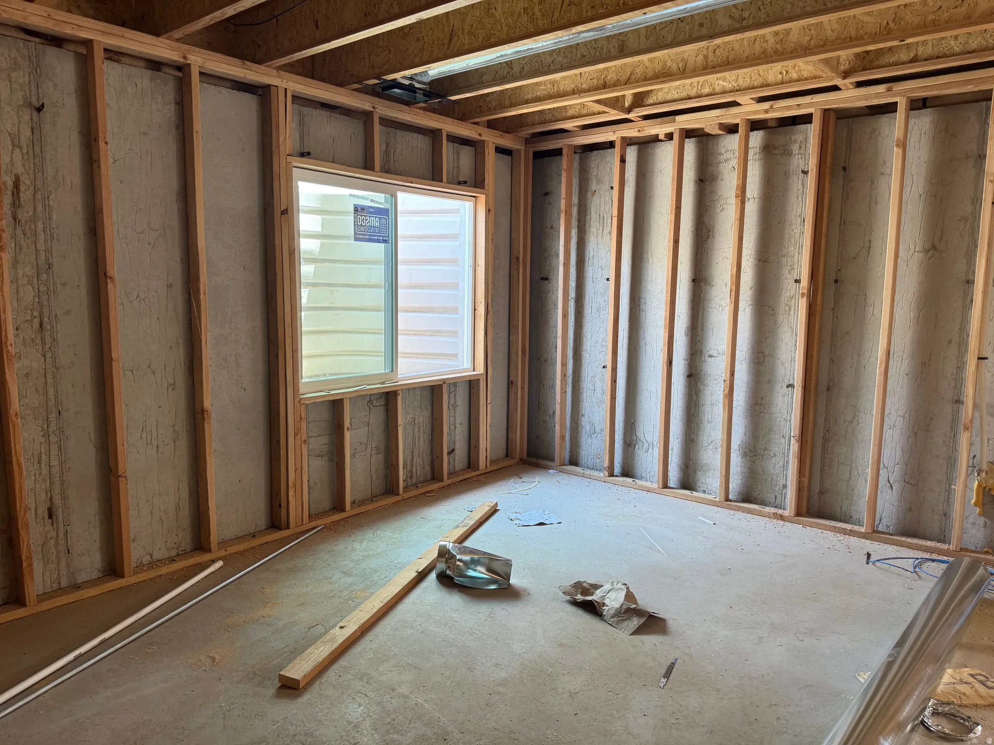 Framed interior space featuring a newly installed horizontal sliding window with a white frame