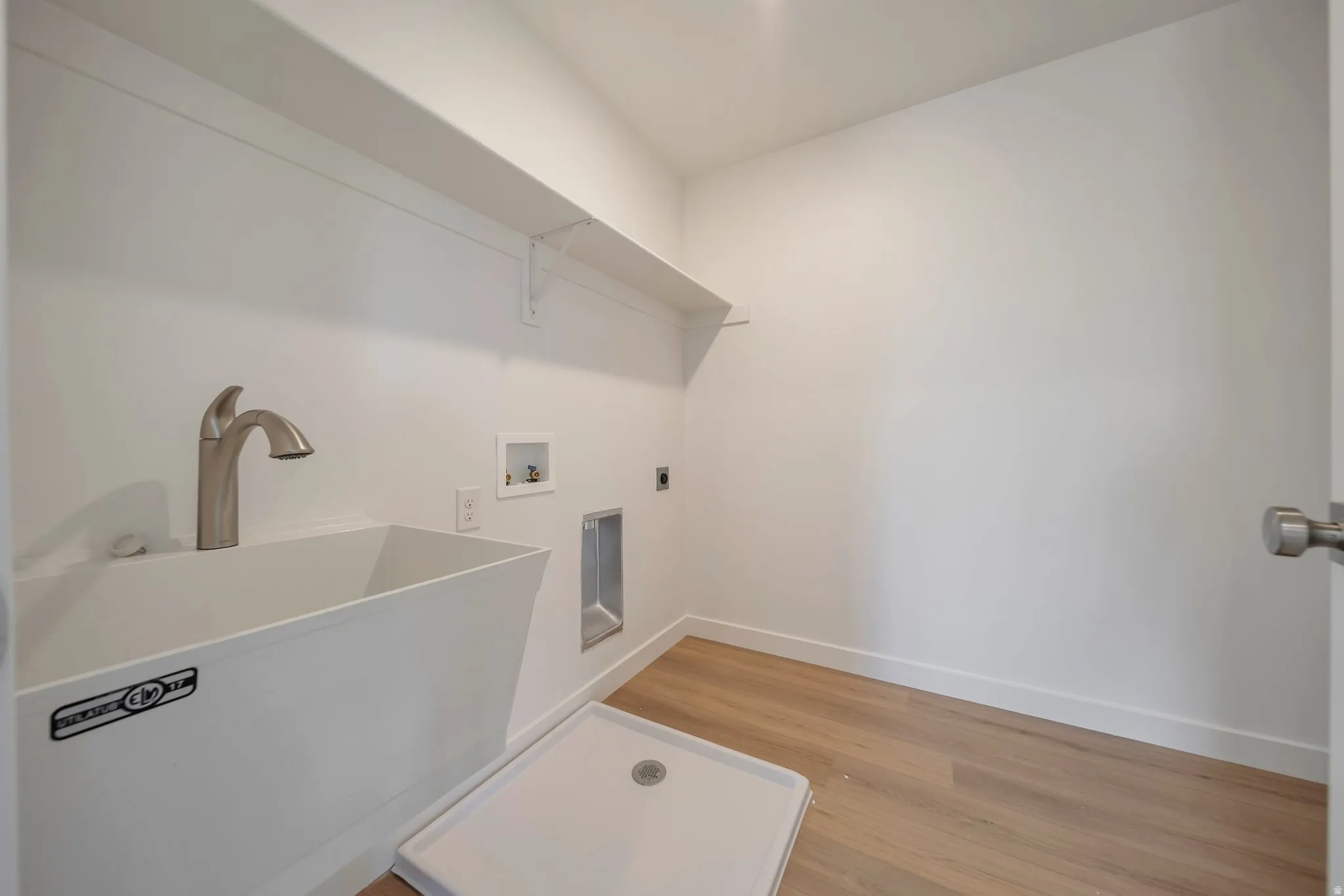 Laundry area featuring light wood-style floors, hookup for an electric dryer, and hookup for a washing machine