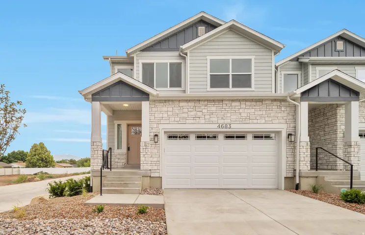 Craftsman house featuring stone siding, board and batten siding, driveway, and an attached garage