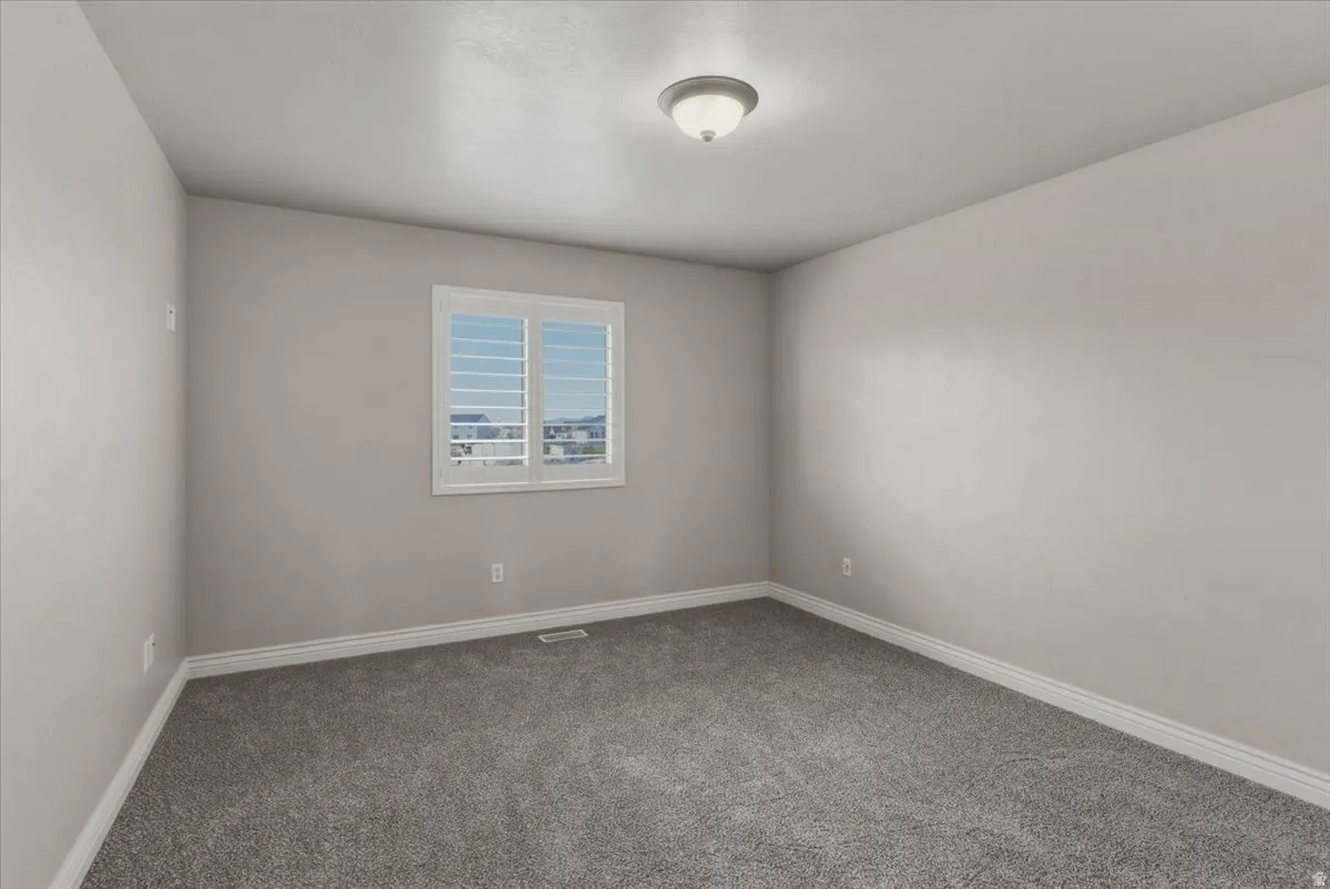 Carpeted spare room with baseboards