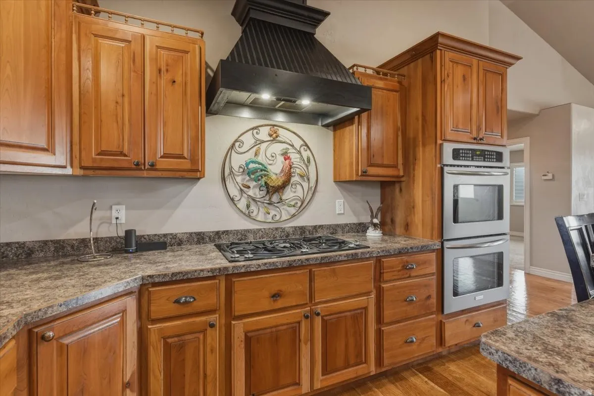 Kitchen featuring wood finish cabinetry, stainless steel appliances, and light wood-style flooring