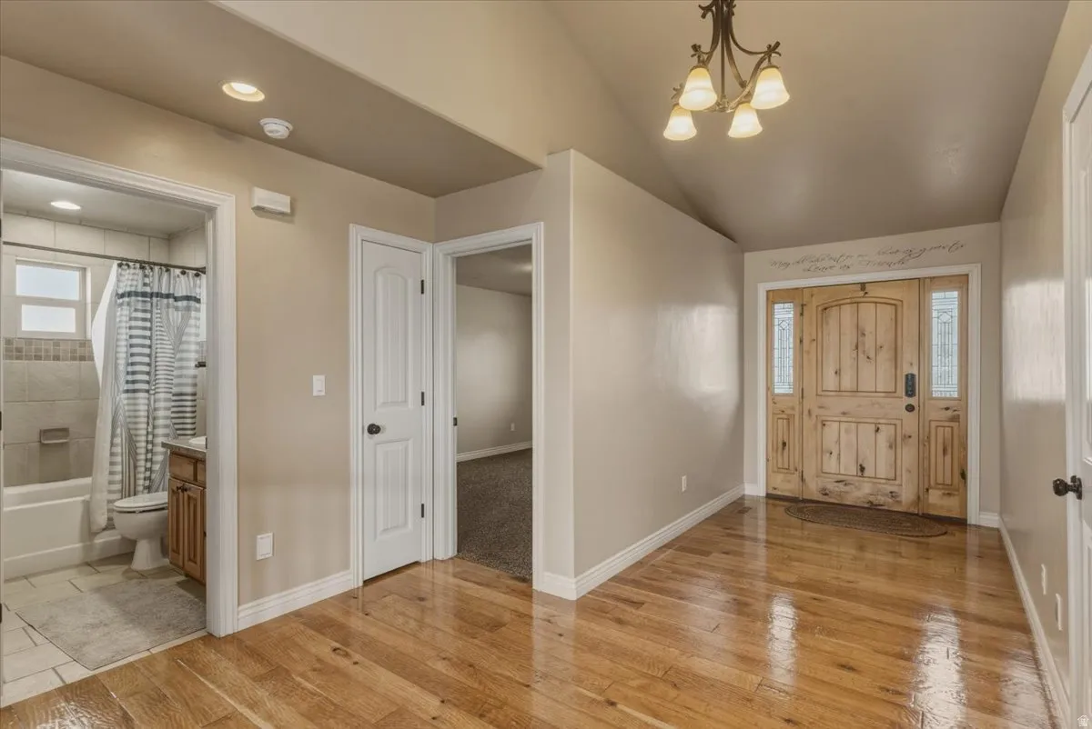 Entrance foyer featuring suspended lighting and light wood-style flooring