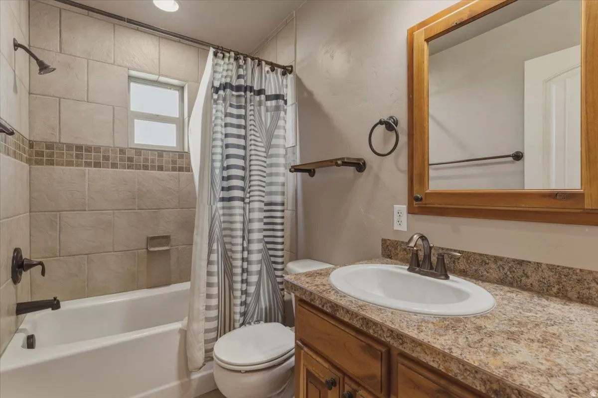 Full bath featuring vanity and shower / bath combo with shower curtain