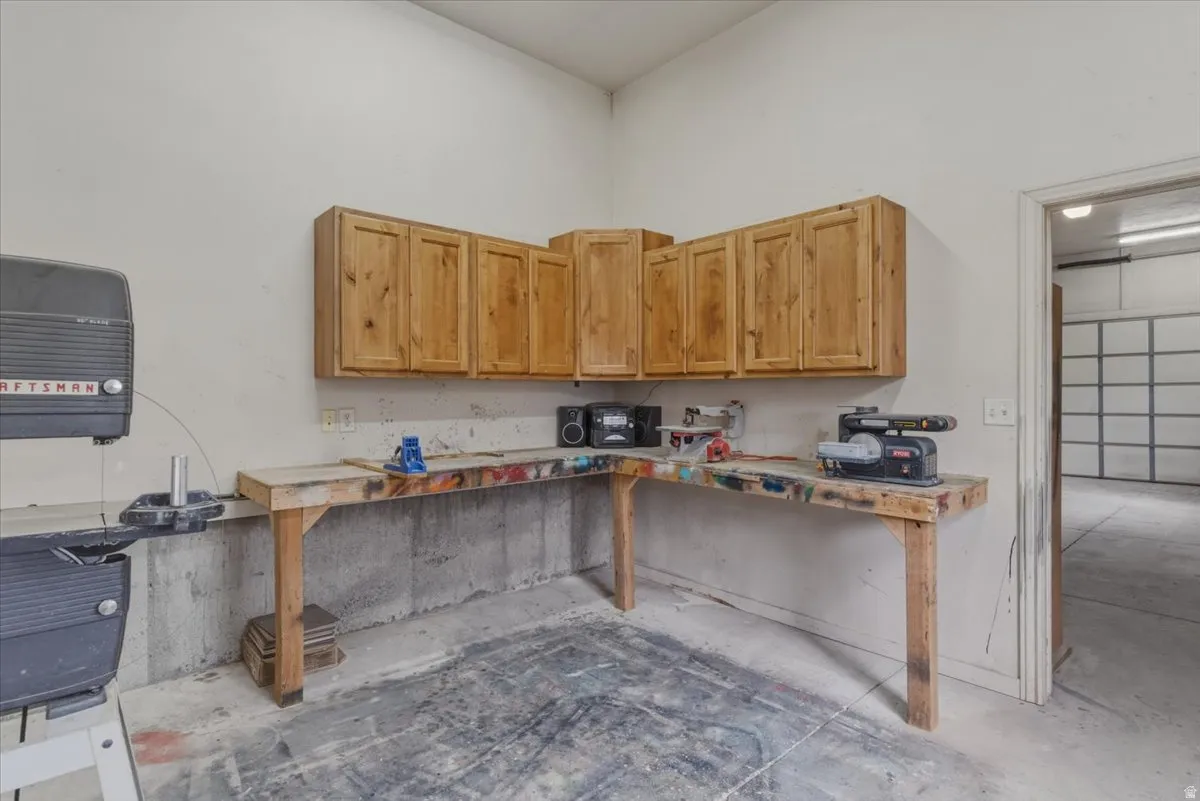 Kitchen featuring concrete flooring, a high ceiling, and light wood finish cabinetry