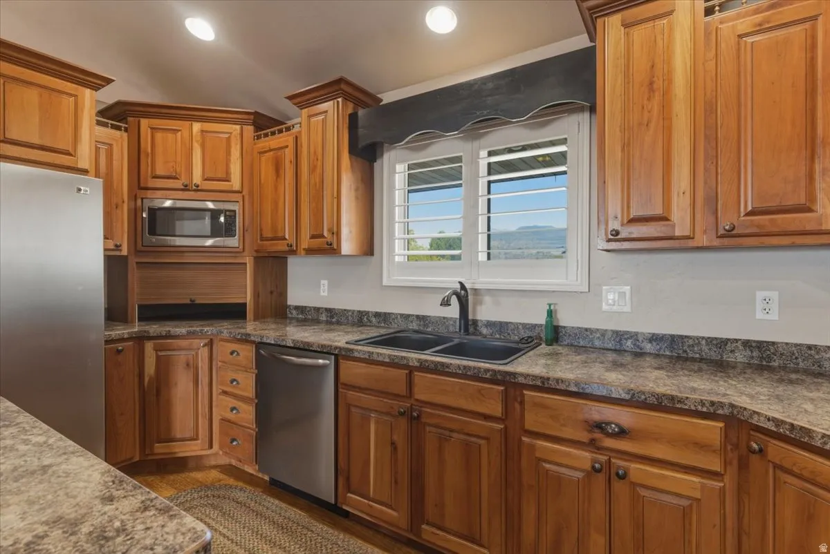Kitchen with stainless steel appliances, wood finish cabinetry, and recessed lighting
