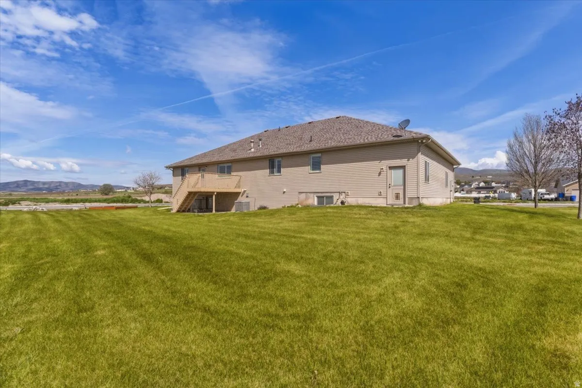 Back of property with a mountain view and a yard