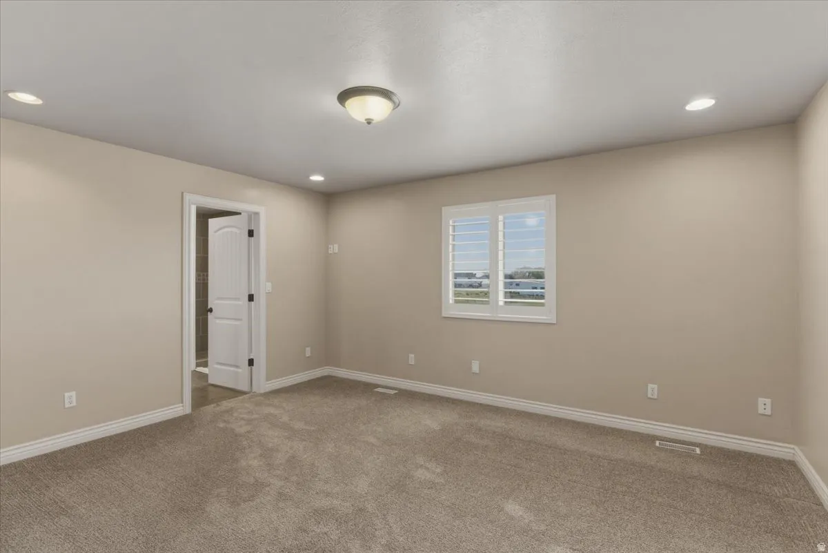Unfurnished room with recessed lighting and carpet