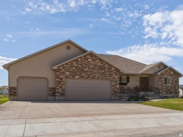 Ranch-style house featuring a porch, an attached garage, a front yard, and concrete driveway