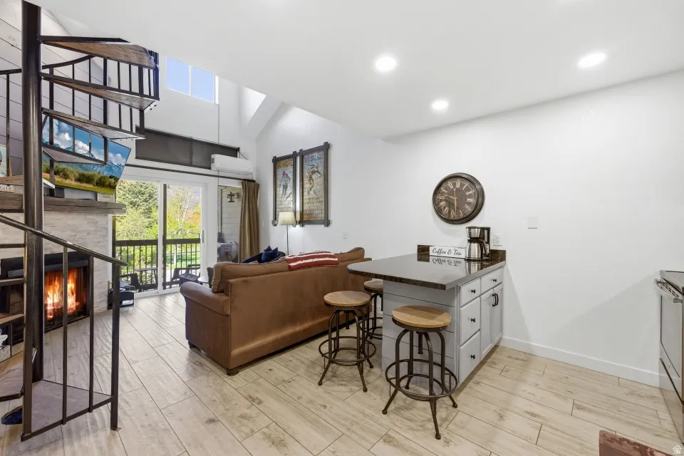 Kitchen featuring a peninsula, a breakfast bar area, dark countertops, open floor plan, and light wood-type flooring