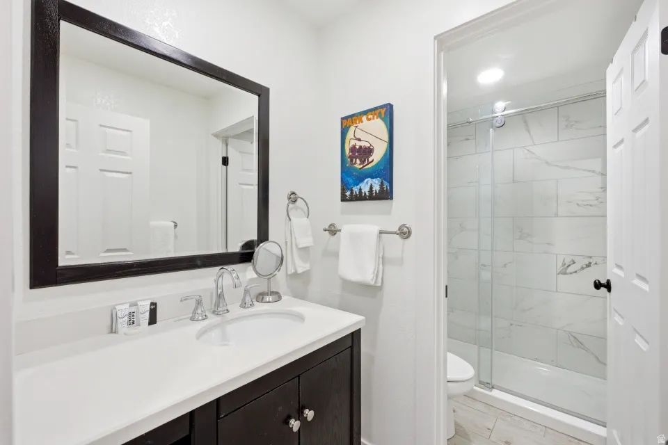 Full bathroom with vanity and a marble finish shower