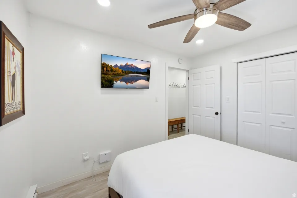 Bedroom with light wood-style floors, a ceiling fan, a closet, and recessed lighting